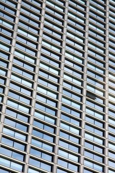 View of a tall modern building with many windows but only one is opened.