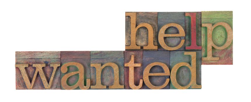 help wanted words in vintage wooden letterpress printing blocks, stained by color inks, isolated on white