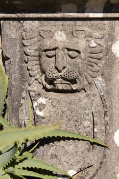 View of  an old carved lion figure on a stone.