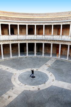 Woman on the center of a circular space surrounded by pillars. 