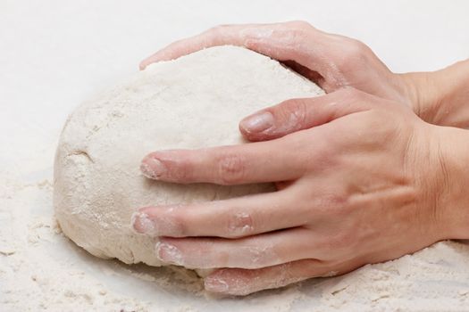 Pair of hands kneading pizza dough.