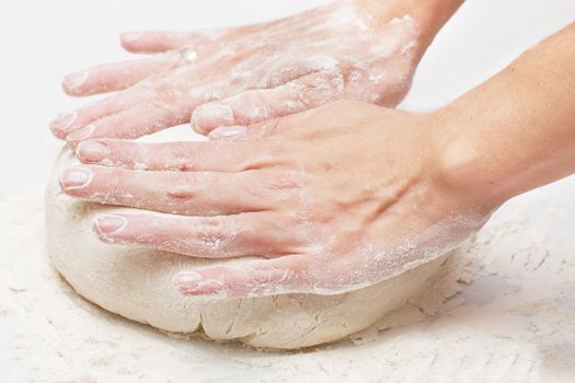 Pair of hands kneading pizza dough.