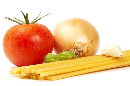 raw macaroni with basil, wet tomato, onion and garlic clove  on white background