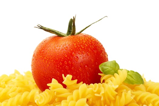 some raw fusilli with wet tomato and basil on white background