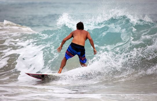 Young men - the surfer in ocean. Bali. Indonesia