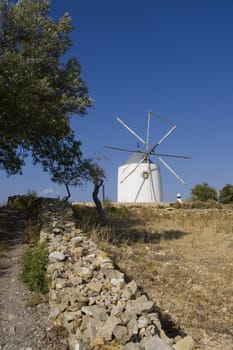 View of a typical portuguese windmill on top of the hill.