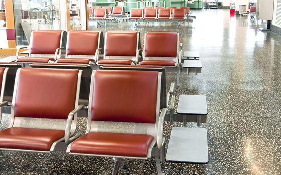 Brown and steel airport seats before gating in waiting room