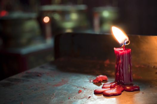 Red holy wax candle in a temple