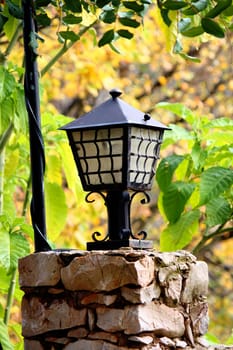 Close detail view of a street light on a pedestal of a park.