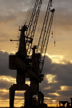 View of two harbor silhouettes cranes at sunset.