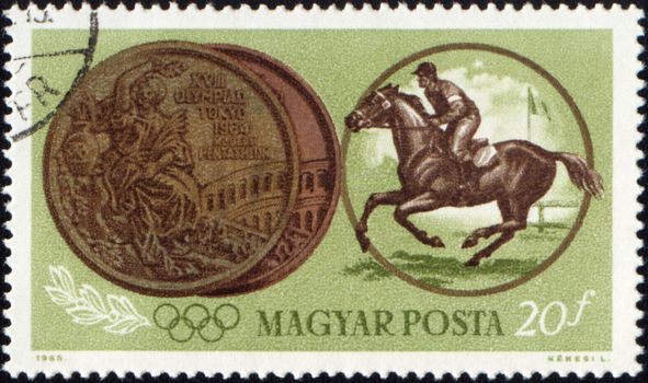 HUNGARY - CIRCA 1965: A post stamp printed in Hungary shows jockey riding horse and Olympic medal, devoted to Olympic games in Tokio, circa 1965