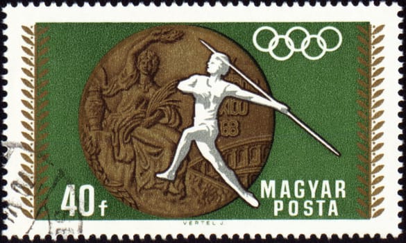 HUNGARY - CIRCA 1968: A post stamp printed in Hungary shows javelin throwin and Olympic medal, devoted to Olympic games in Mexico, circa 1968