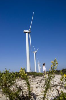 View of a young girl watching a windmill.