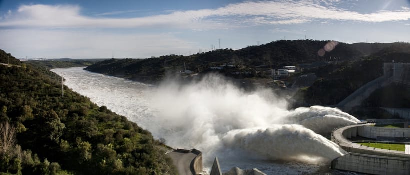 View of two powerful jets of water on the Alqueva dam, Portugal.