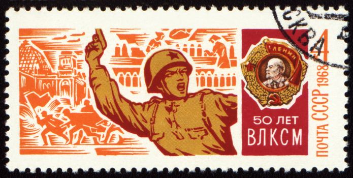 USSR - CIRCA 1968: A stamp printed in USSR, shows Soviet officer with a pistol in battle and Order of Lenin, devoted to the 50-th anniversary of Komsomol, circa 1968