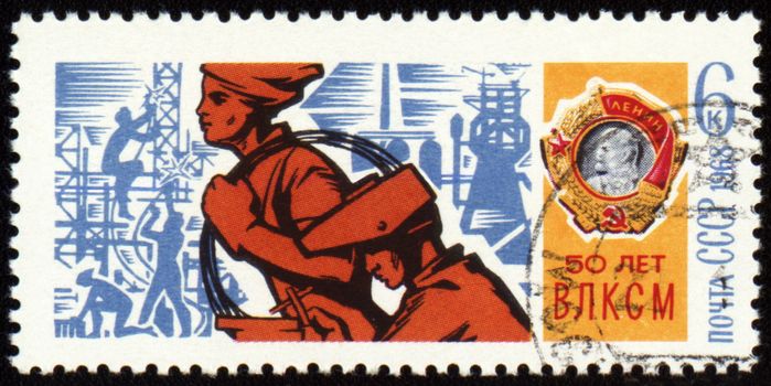 USSR - CIRCA 1968: A stamp printed in USSR, shows young workers and Order of Lenin, devoted to the 50-th anniversary of Komsomol, circa 1968