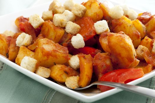 Vegetarian version of hungarian stew with potatoes and peppers and croutons.