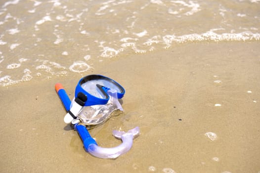 a mask on the beach, near the water of the ocean
