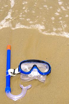 a mask on the beach, near the water of the ocean
