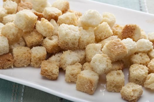 Fresh toasted croutons on a white plate.