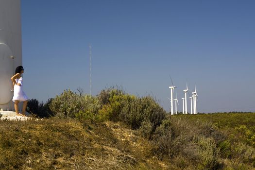 View of a young girl watching a windmill.