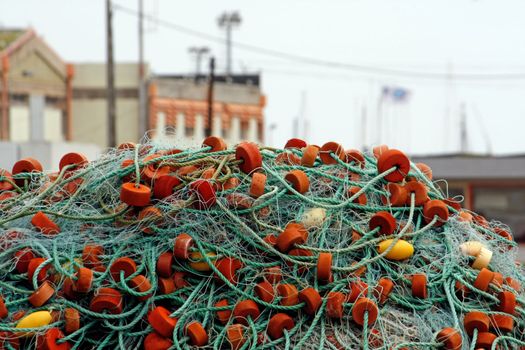 View of a pile of fishing net with plastic floaters on a harbor.