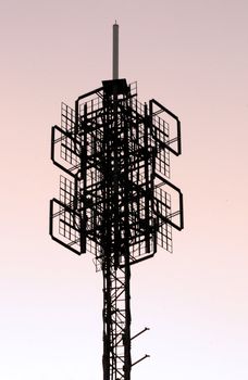 Silhouette view of a cell phone, communications tower structure.