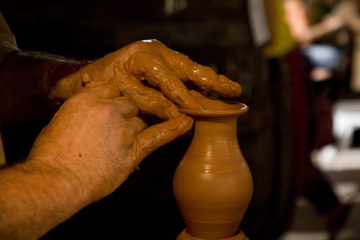 Close up view of the hands of a potter working on a new piece.