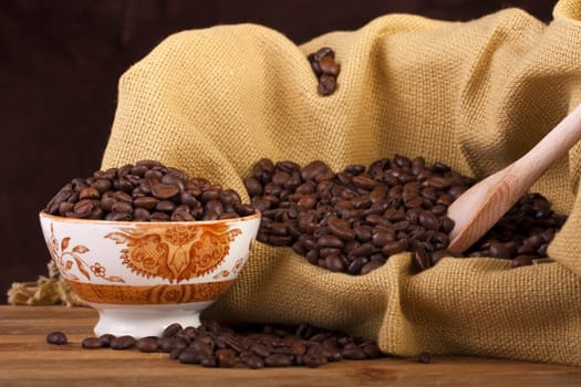 Close view of a bunch of roasted beans of coffee inside a bowl.