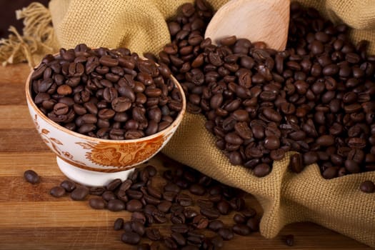 Close view of a bunch of roasted beans of coffee inside a bowl.