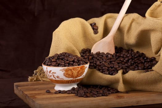 Close view of a bunch of roasted beans of coffee inside a bowl.