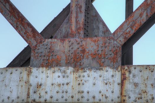 Framework of rusty old steel beams and girders with backdrop sky