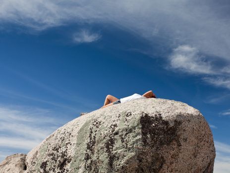Female hiker lying on rock on summit of Old Rag in Shenandoah valley