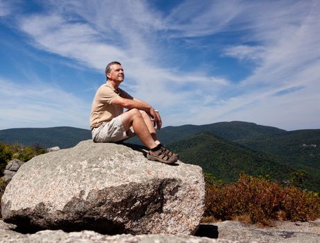 Senior hiker looks over valley in the Shenandoah on a climb of Old Rag