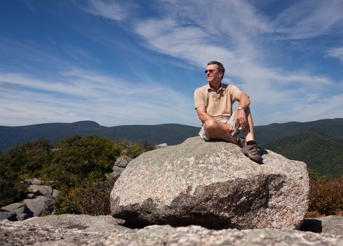 Senior hiker looks over valley in the Shenandoah on a climb of Old Rag