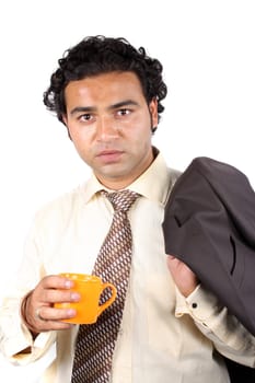 A young Indian businessman having a coffee during an office break.