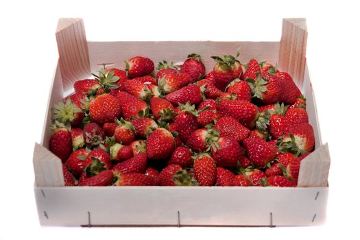 Close view of a wooden box filled with strawberries isolated on a white background.