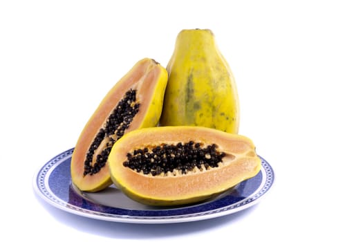 Close up view of papaya fruit sliced presented on a dish. 