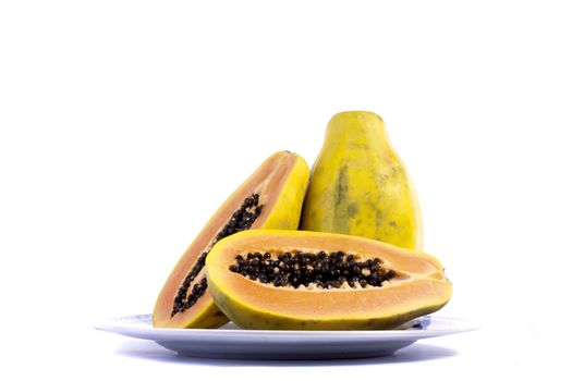 Close up view of papaya fruit sliced presented on a dish. 