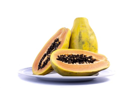 Close up view of papaya fruit sliced presented on a dish. 