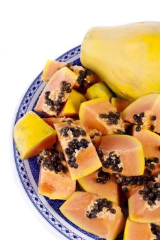 Close up view of papaya fruit sliced presented on a dish. 