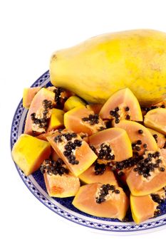 Close up view of papaya fruit sliced presented on a dish. 