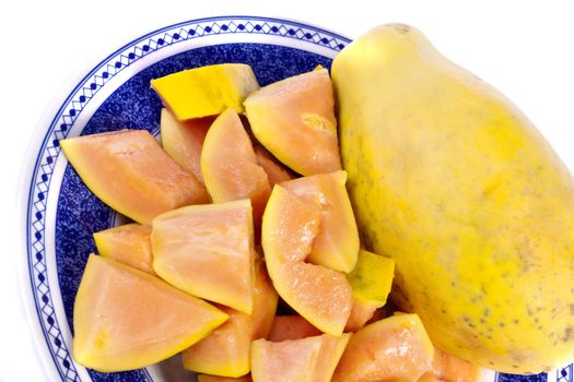 Close up view of papaya fruit sliced presented on a dish. 