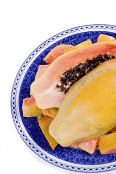 Close up view of papaya fruit sliced presented on a dish. 