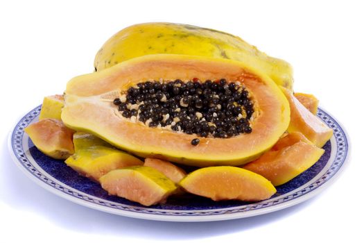 Close up view of papaya fruit sliced presented on a dish. 