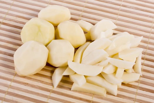 Close up view of some sliced potatoes isolated on bamboo background.