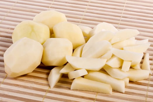 Close up view of some sliced potatoes isolated on bamboo background.