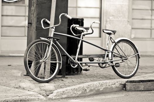 An old two seater bike parked on the streets