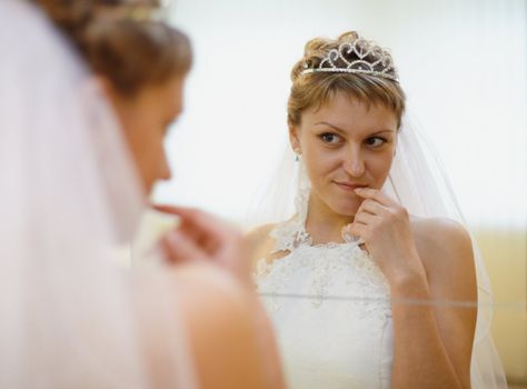Young bride admires himself in the mirror
