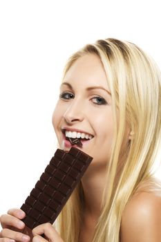 beautiful blonde woman eating a chocolate bar on white background